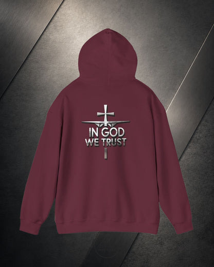 Maroon hoodie with 'In God We Trust' text and cross design on a metallic surface