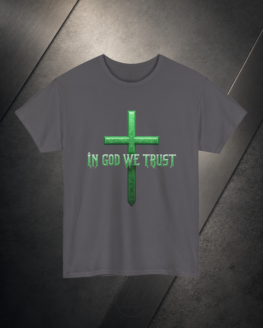 Gray t-shirt with green cross and 'In God We Trust' text on a dark surface