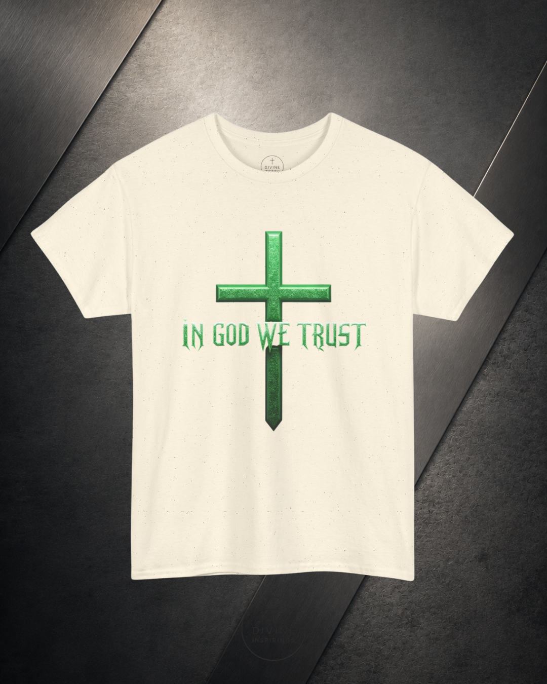 White t-shirt with green cross and 'In God We Trust' text on a dark surface