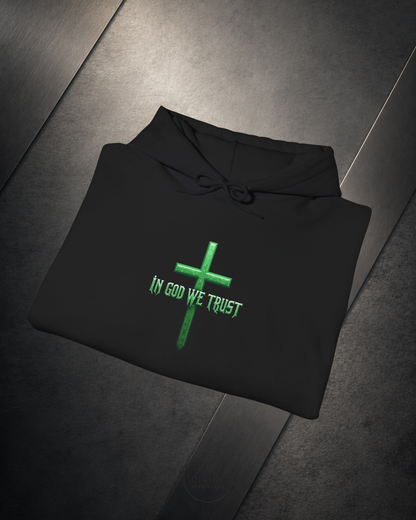 Black hoodie with green cross and 'In God We Trust' text on a dark surface