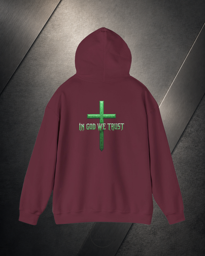 Maroon hoodie with green cross and 'In God We Trust' text on a dark surface