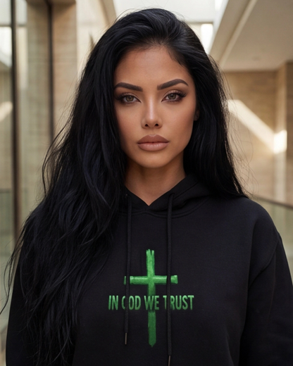 Woman wearing a black hoodie with a green cross and 'IN GOD WE TRUST' text.