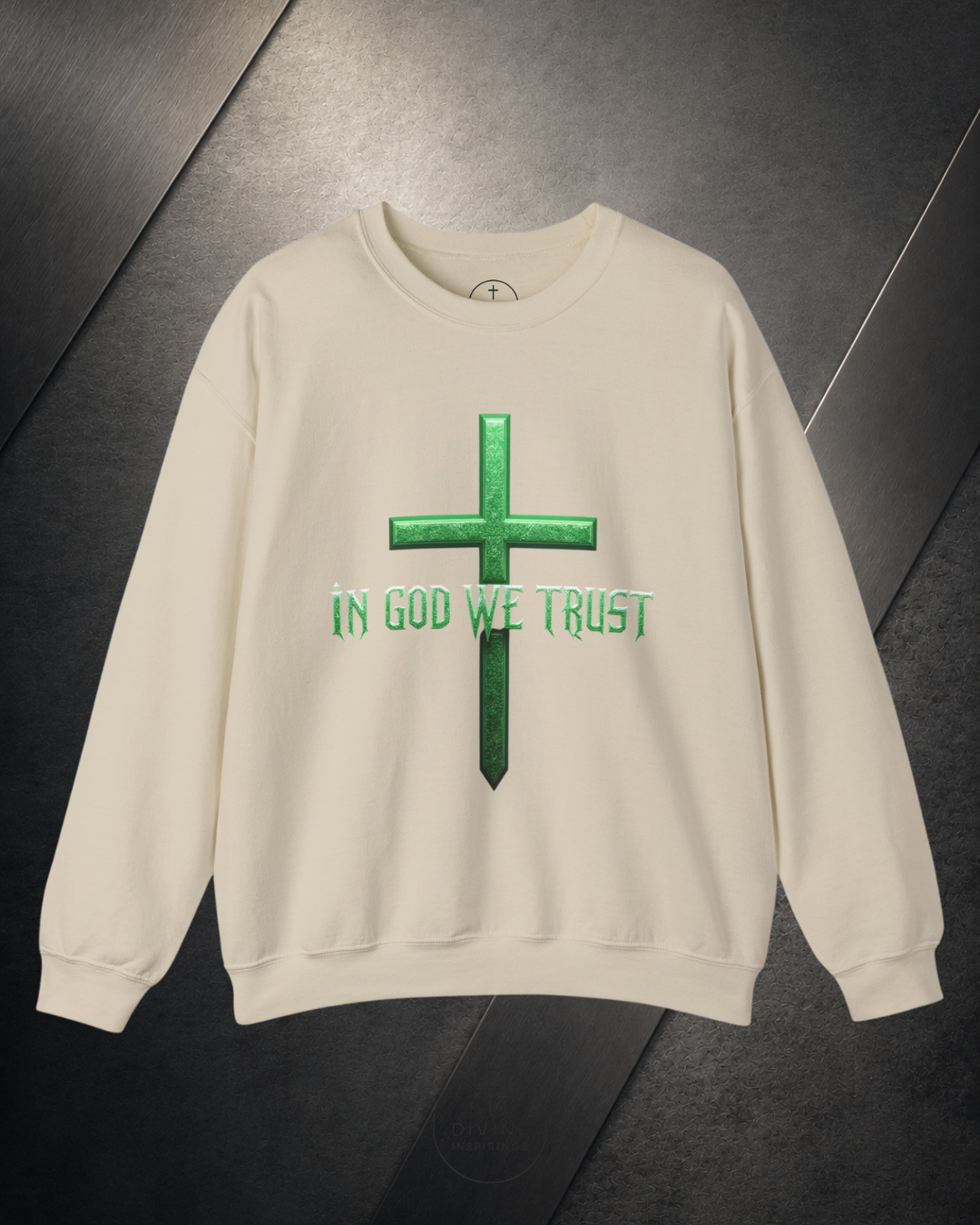 Beige sweatshirt with green cross and 'IN GOD WE TRUST' text on a dark surface