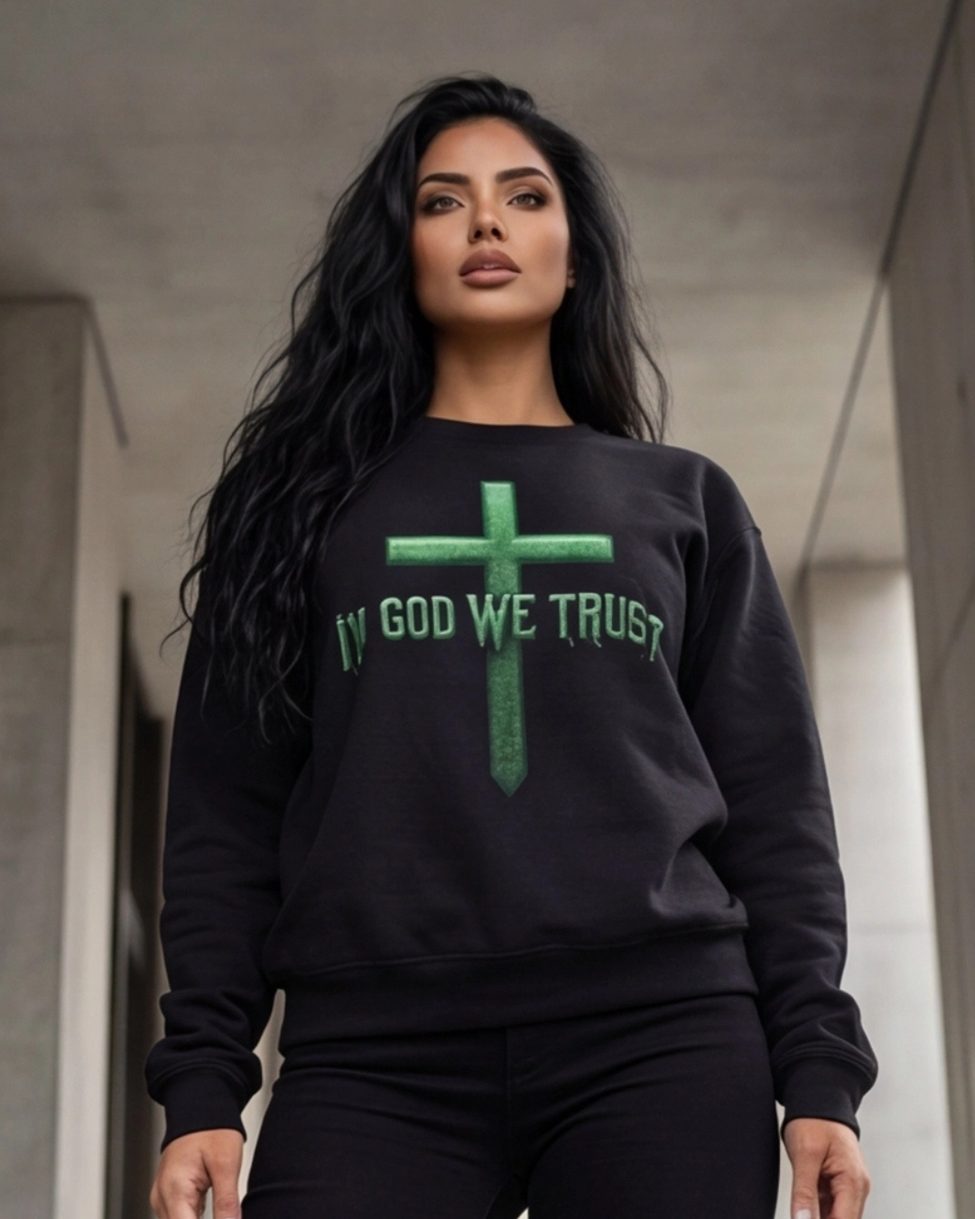 Woman wearing a black sweatshirt with 'IN GOD WE TRUST' text and green cross design.