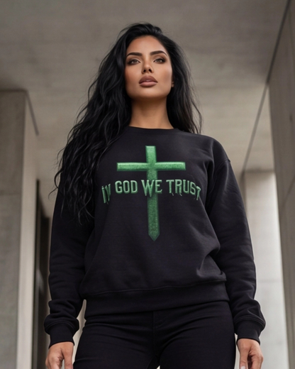 Woman wearing a black sweatshirt with 'IN GOD WE TRUST' text and green cross design.