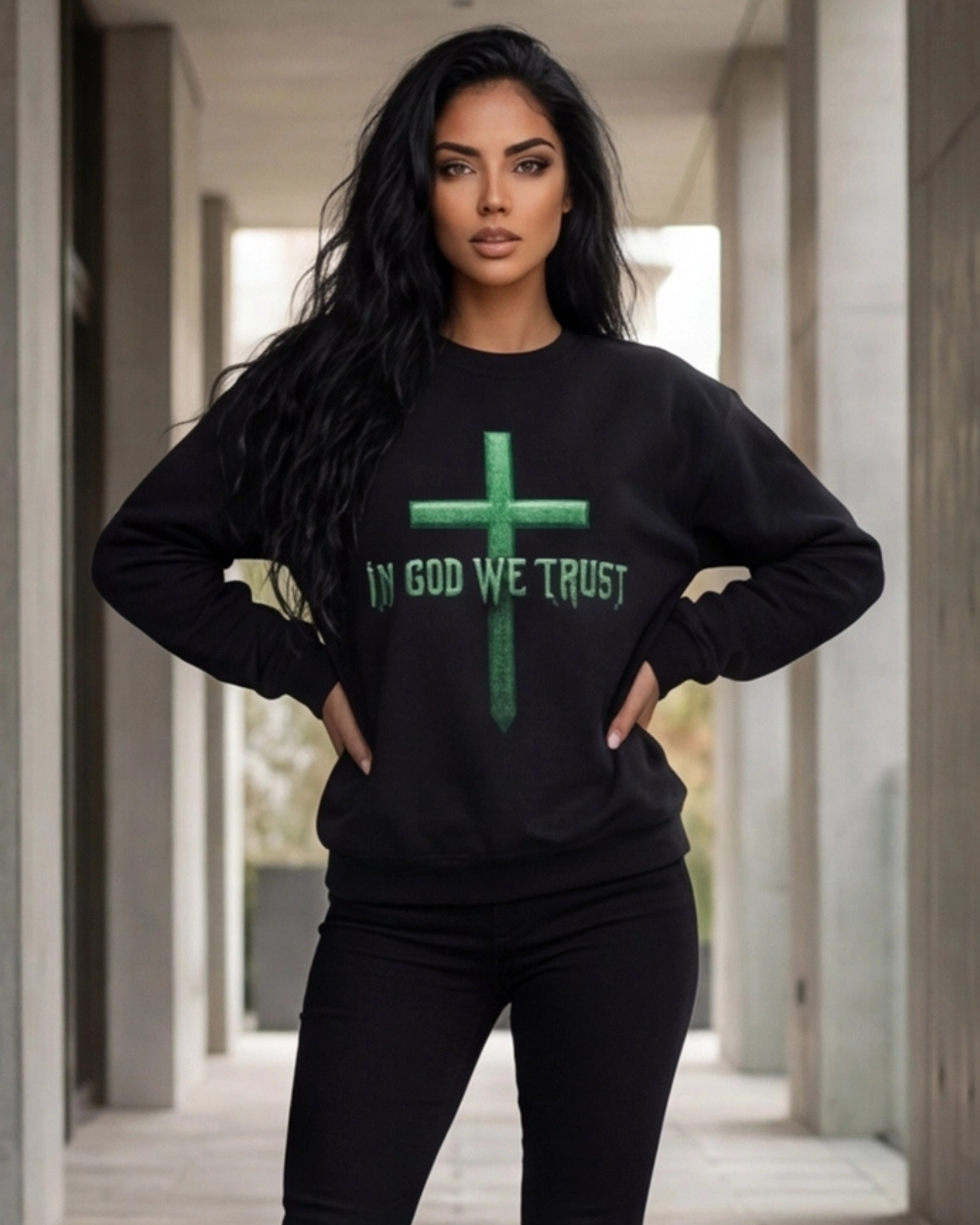 Woman wearing a black sweatshirt with 'IN GOD WE TRUST' printed on it in an urban setting.
