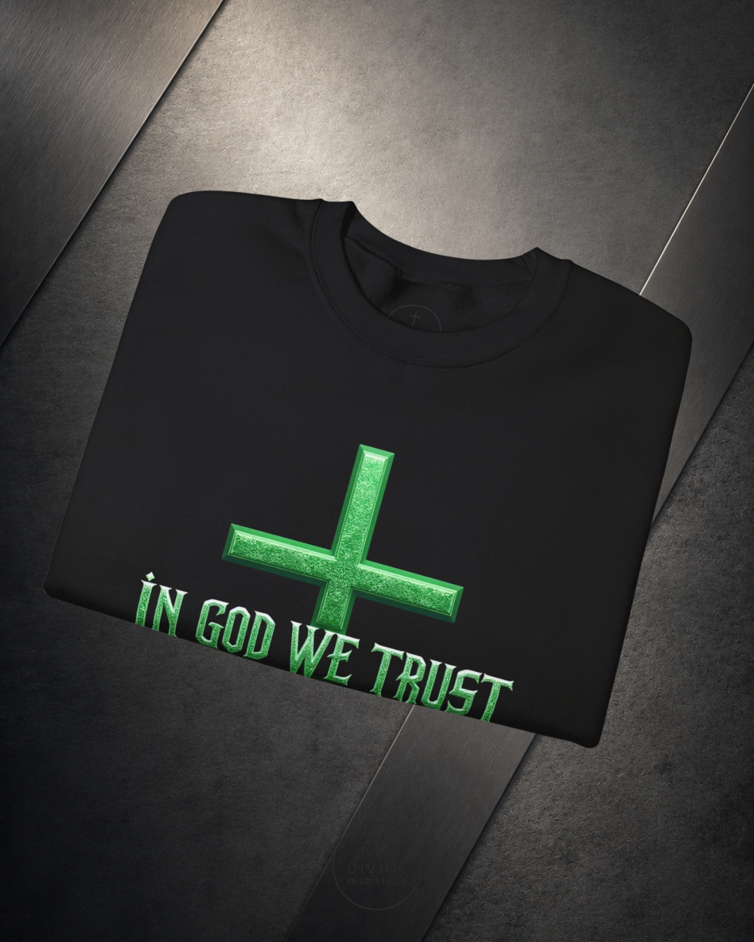Black sweatshirt with green cross and 'IN GOD WE TRUST' text on a dark surface