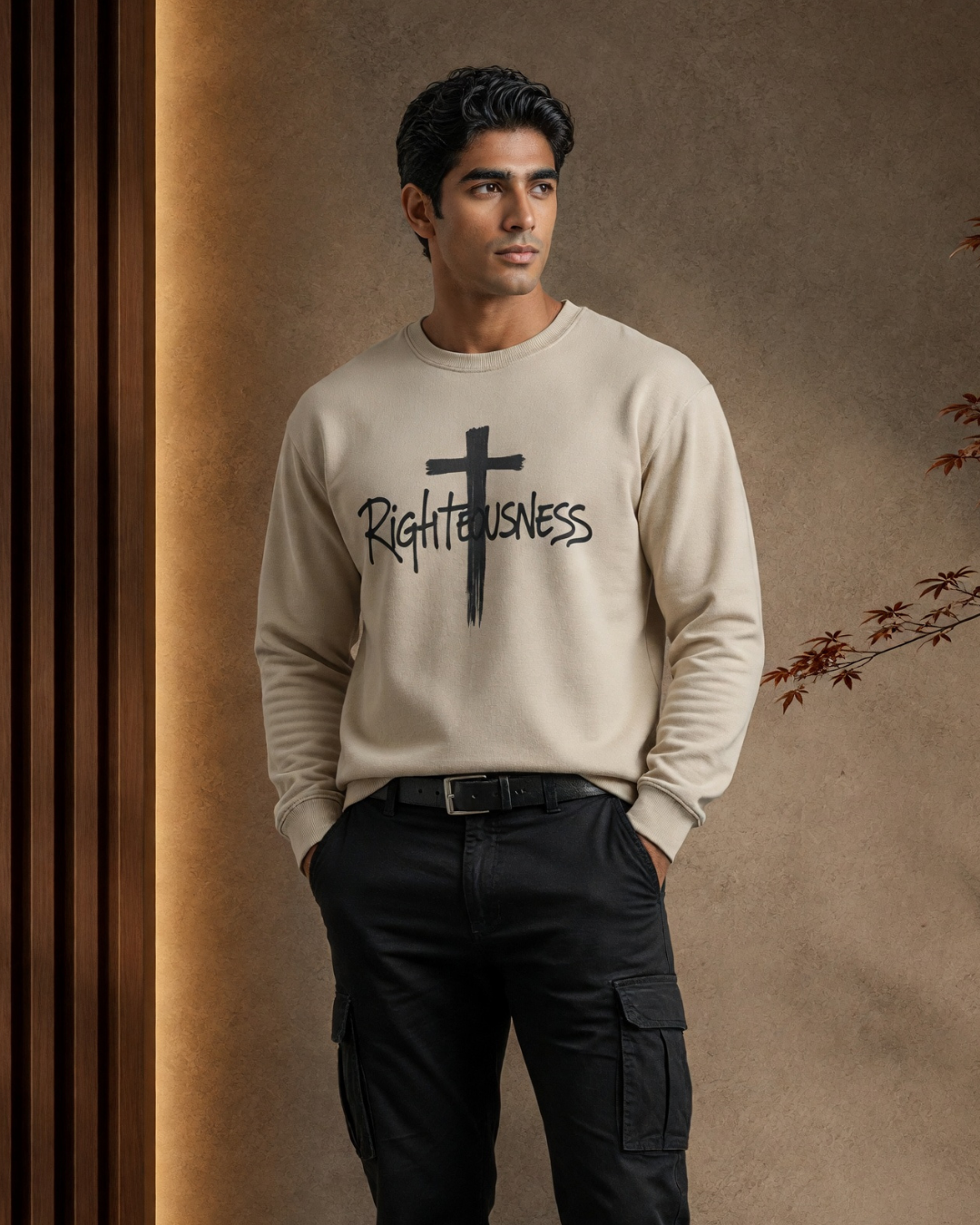 Man wearing a beige sweatshirt with 'Righteousness' text and cross graphic against a brown background
