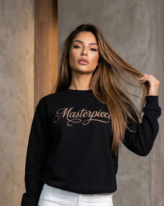 Woman wearing a black sweatshirt with 'Masterpiece' text against a neutral background