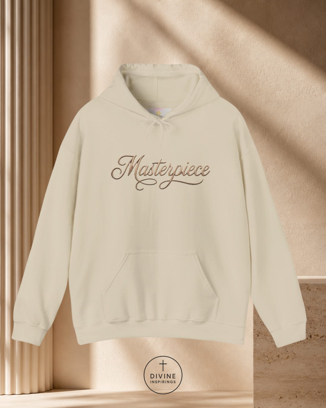 Beige hoodie with 'Masterpiece' text on a beige background