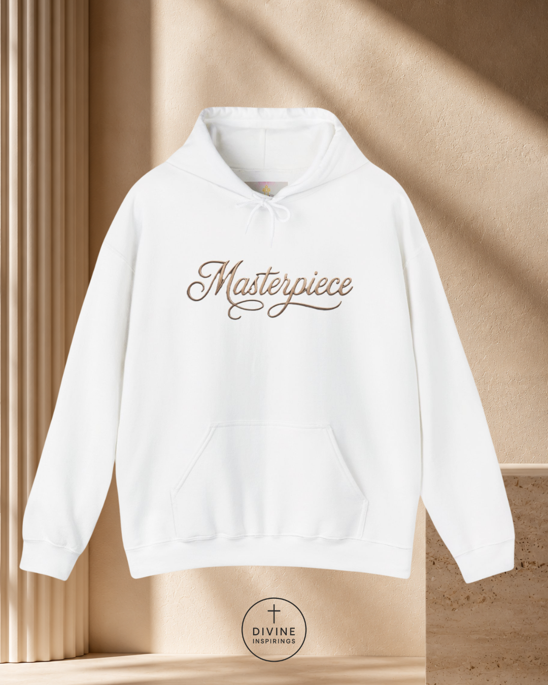 White hoodie with 'Masterpiece' text on a beige background