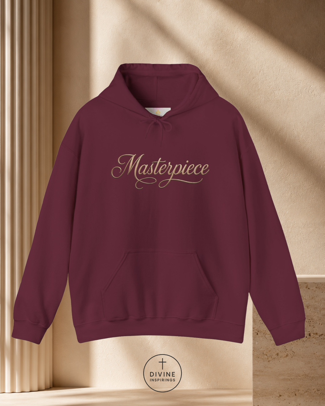 Maroon hoodie with 'Masterpiece' text on a beige background