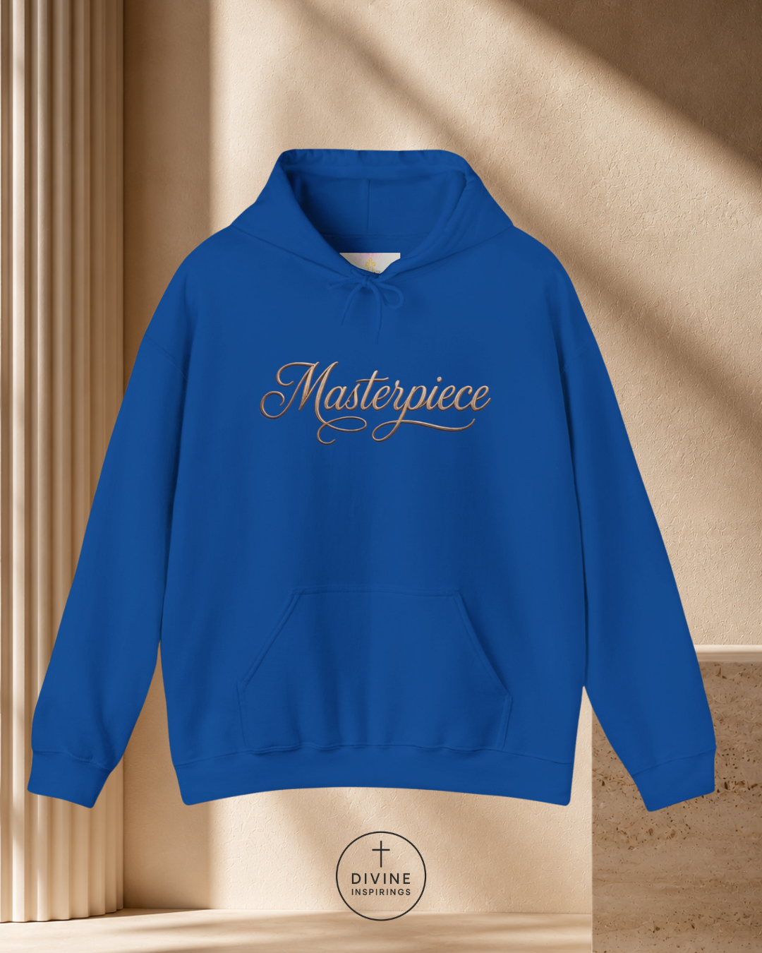Blue hoodie with 'Masterpiece' text on a beige background