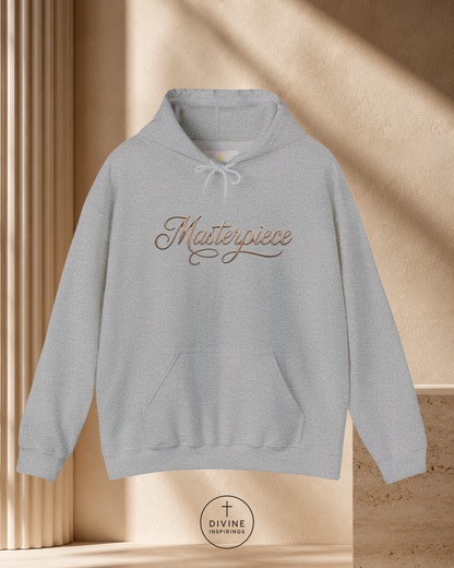 Gray hoodie with 'Masterpiece' text on a beige background