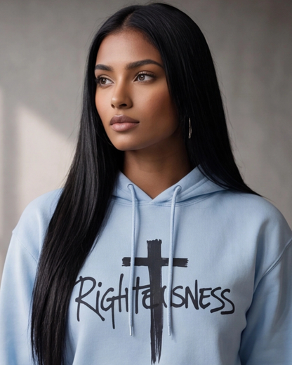 Woman wearing a light blue hoodie with 'Righteousness' text and cross design on a neutral background