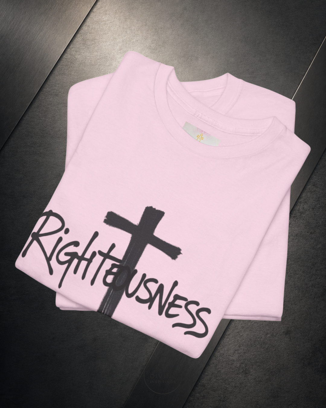 Pink t-shirt with a cross and 'Righteousness' text on a dark surface