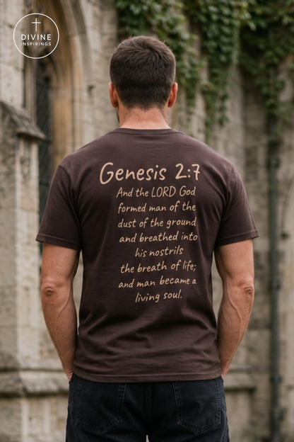 A man viewed from behind wearing a dark brown t-shirt with a beige Bible verse printed on the back, standing in front of a stone wall with green ivy.
