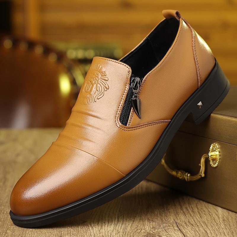 Brown leather shoe with a zipper on a wooden surface