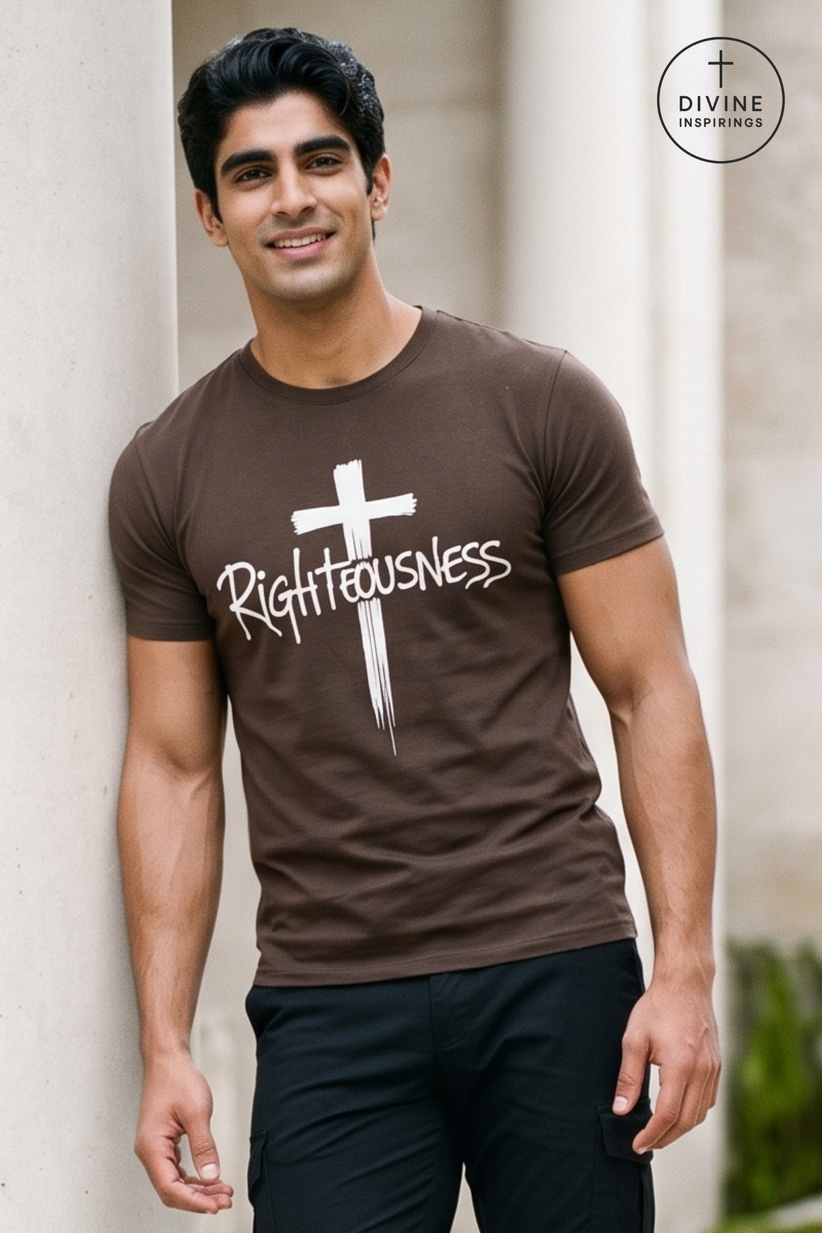 A man wearing a brown crewneck t-shirt with a white cross and the word 'Righteousness' printed on the front, posing against a light-colored stone wall. A circular 'DIVINE INSPIRINGS' logo is visible in the top right corner.