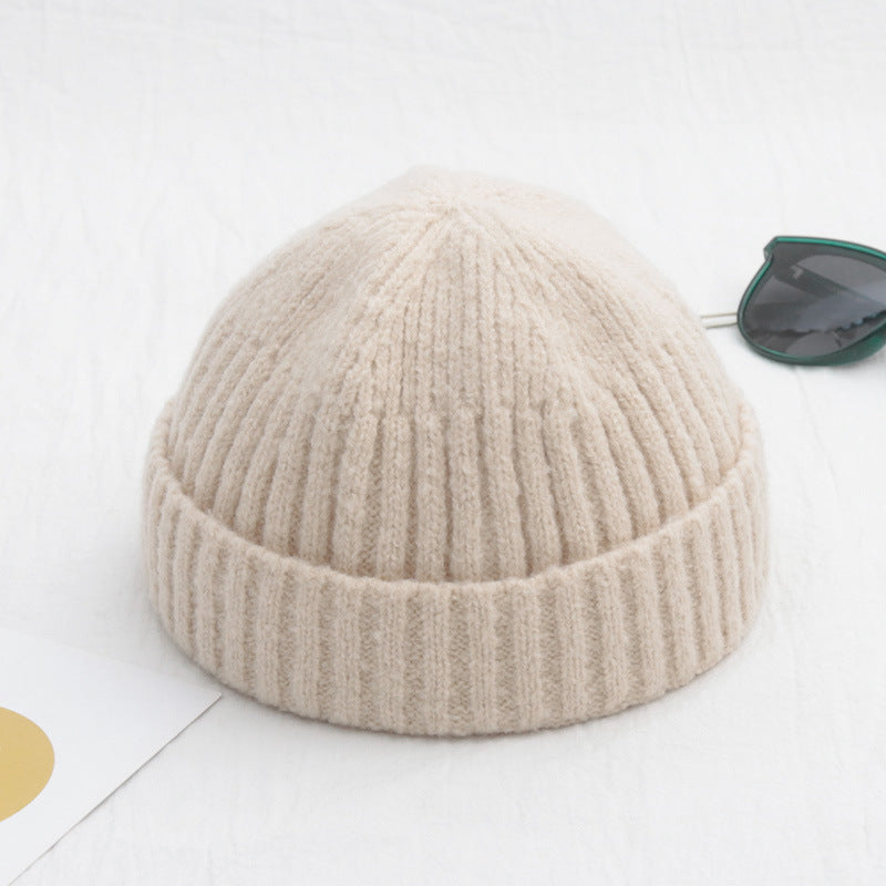 Beige knit beanie on a white background