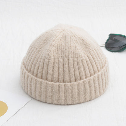 Beige knit beanie on a white background