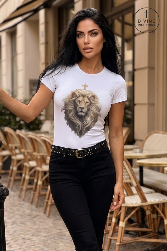 A woman wearing a white crewneck t-shirt with a detailed lion graphic and a small cross on the chest, paired with black pants and a studded belt, standing on an outdoor cafe patio.