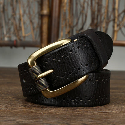 Black leather belt with a gold buckle on a wooden surface.