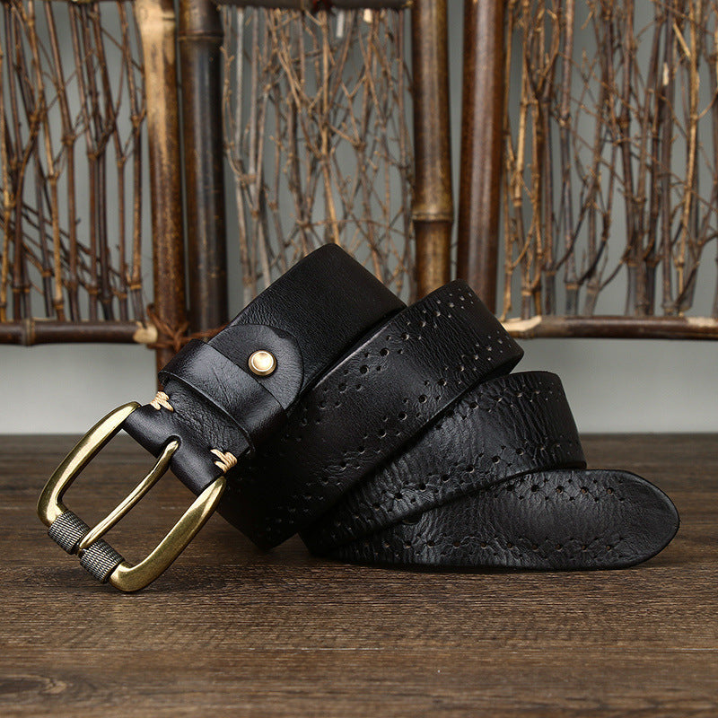 Black leather belt with gold buckle on a wooden surface