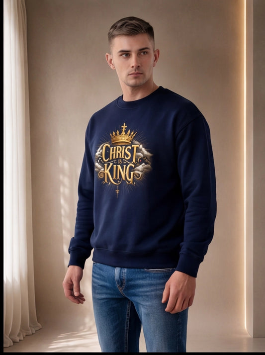 Man wearing a navy blue sweatshirt with 'Christ the King' text and design indoors.