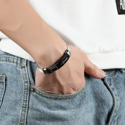Person wearing a black and silver bracelet on a white background