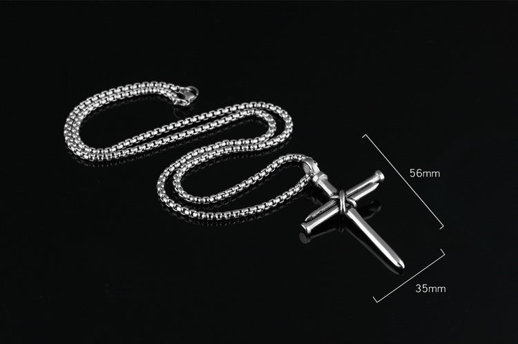 Silver chain necklace with a cross pendant on a black background