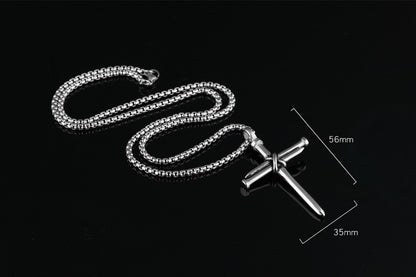 Silver chain necklace with a cross pendant on a black background