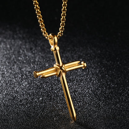 Gold cross necklace with a nail detail on a black textured background