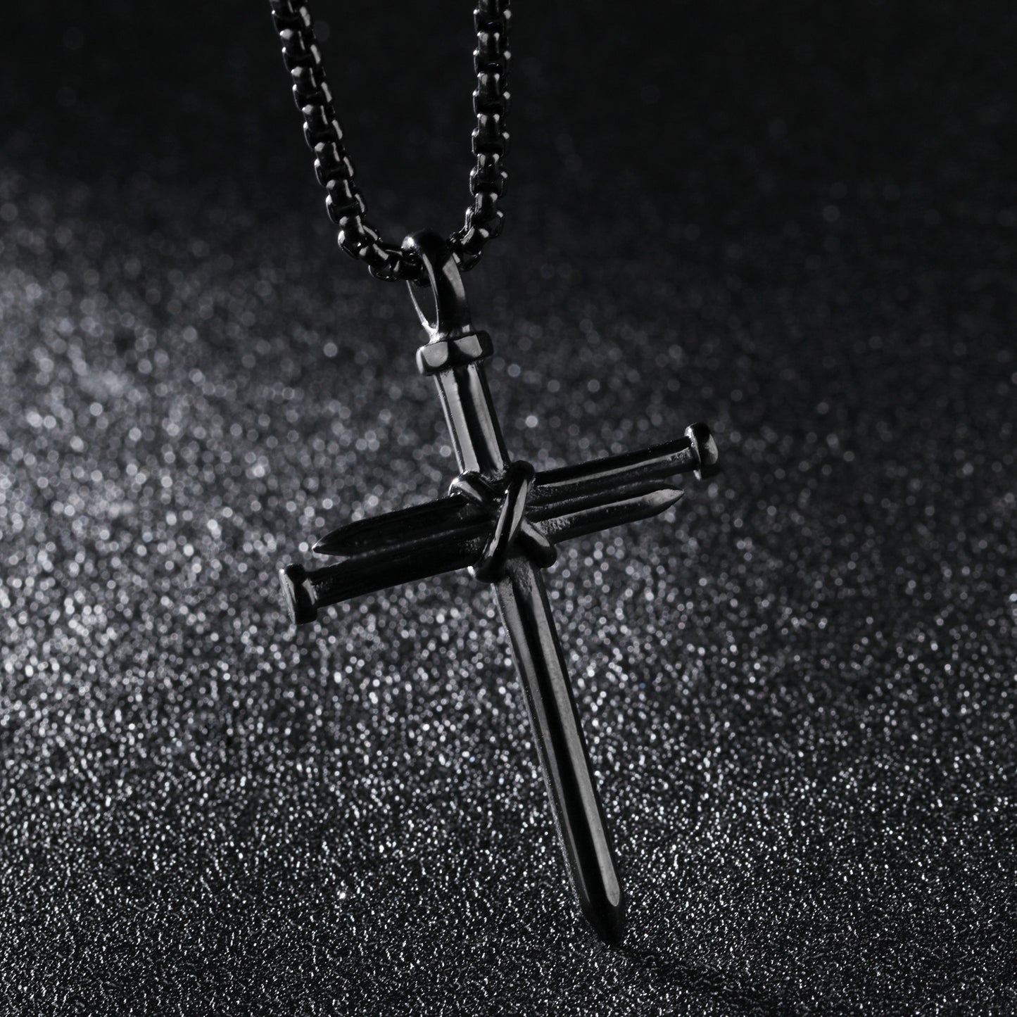 Black cross pendant necklace on a dark textured background