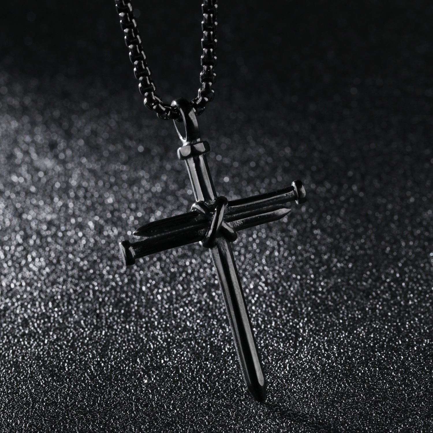 Black cross pendant necklace on a dark textured background