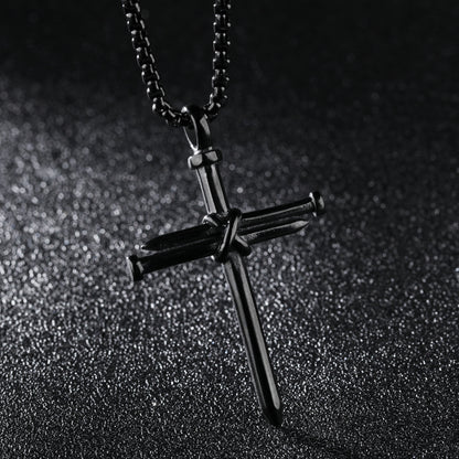Black cross pendant necklace on a dark textured background