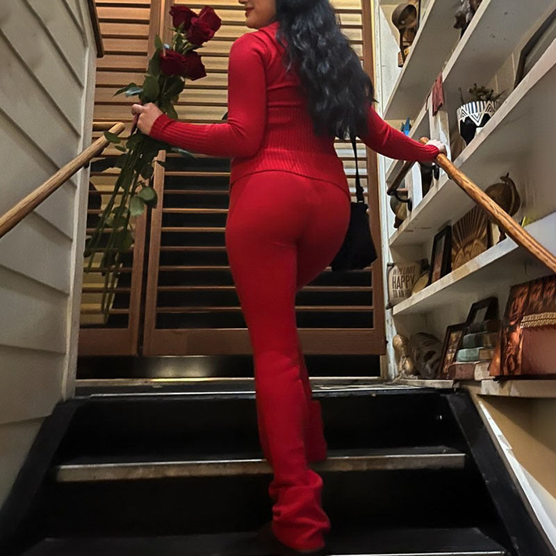 Person in a red outfit holding flowers on a staircase.