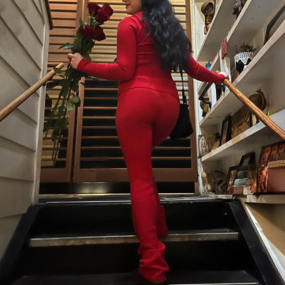 Person in a red outfit holding flowers on a staircase.