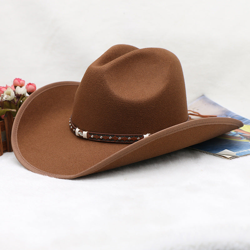 Brown cowboy hat with decorative band on a white surface