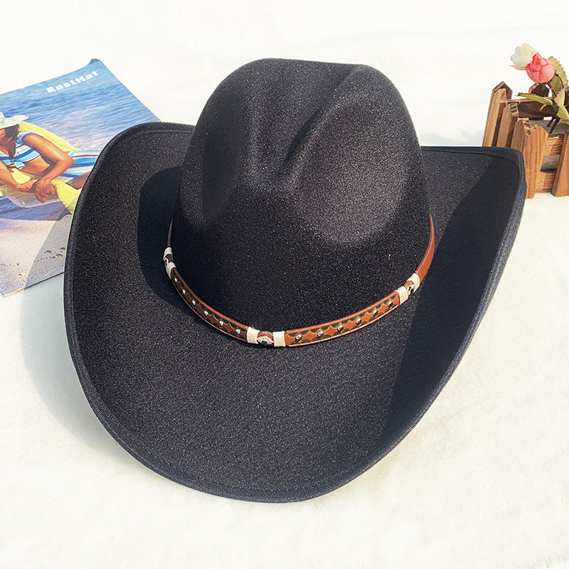 Black cowboy hat with a brown leather band on a white surface