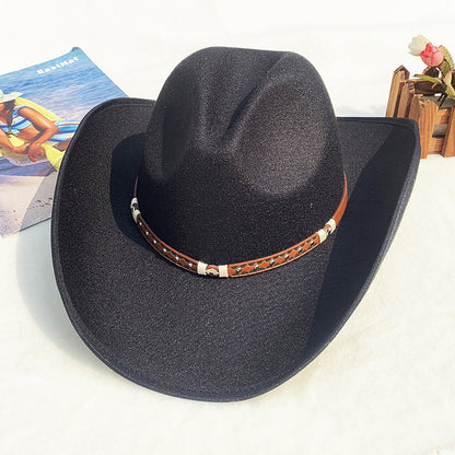 Black cowboy hat with a brown leather band on a white surface
