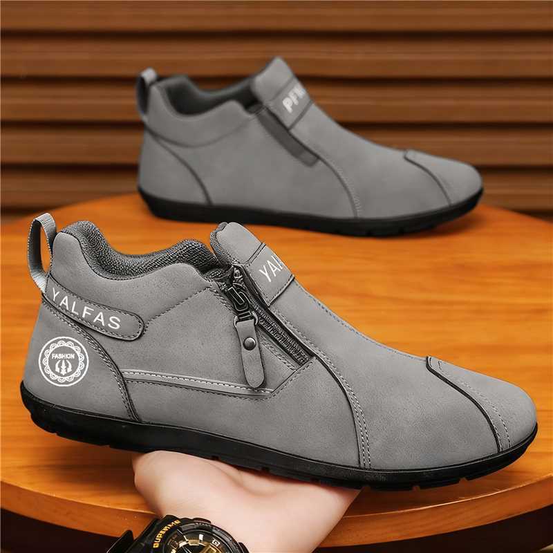 Gray ankle boots with a zipper on a wooden surface.