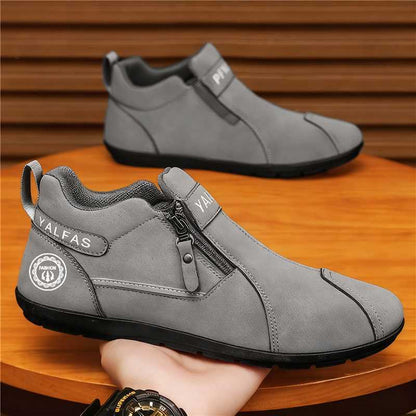 Gray ankle boots with a zipper on a wooden surface.