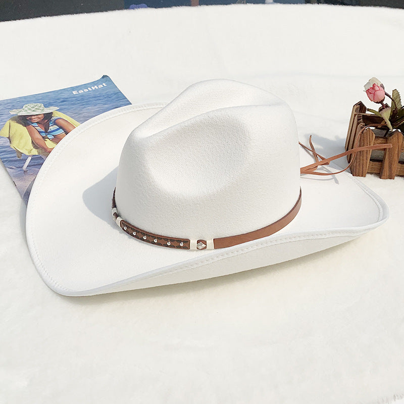 White cowboy hat with a brown band on a white surface