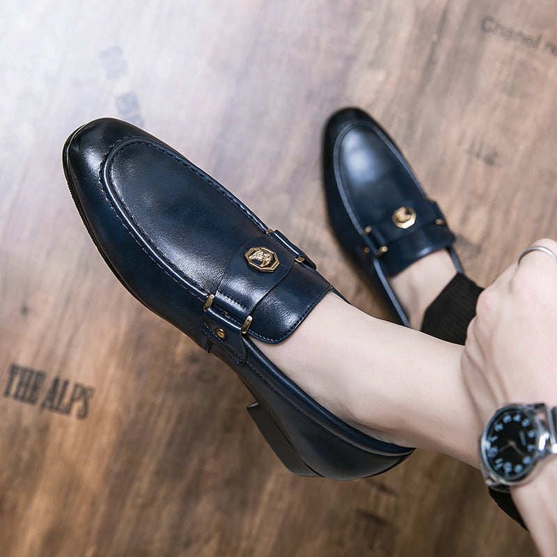 Blue leather loafers with gold accents on a wooden floor.