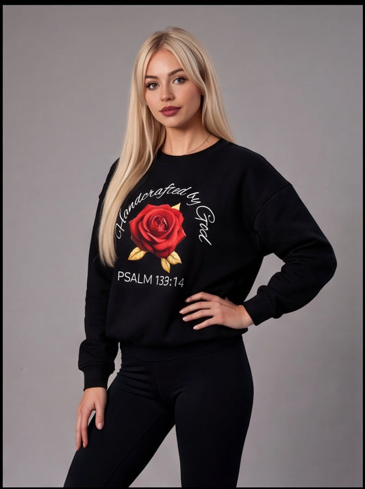 Woman wearing a black sweatshirt with a red rose graphic and text on a gray background