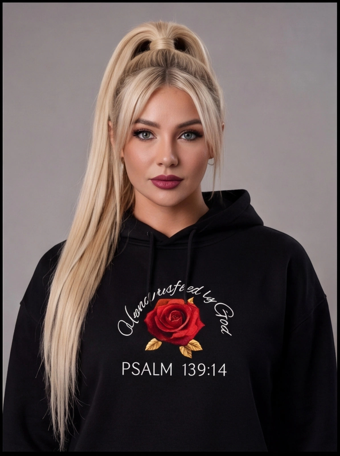 Woman wearing a black hoodie with a red rose design and text on a gray background