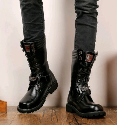 Black leather boots worn with black pants on a wooden floor.