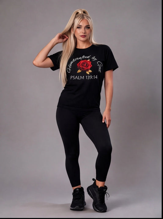 Woman wearing a black t-shirt with a rose design and text on a gray background