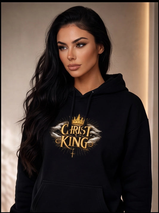 Woman wearing a black hoodie with 'Christ King' design on a neutral background